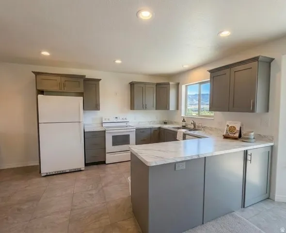 Kitchen featuring gray cabinetry, white countertops, tile flooring, and recessed lighting