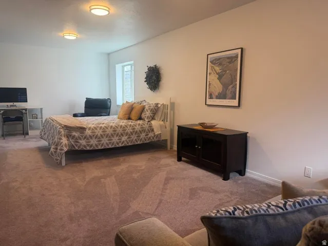 Carpeted flooring, recessed lighting, neutral wall tones, and a window for natural light