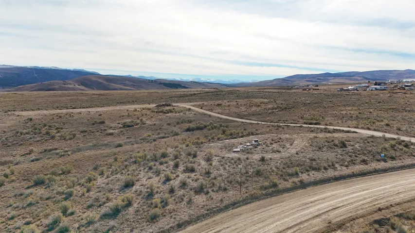 Expansive desert landscape featuring a dirt road and distant mountainous terrain