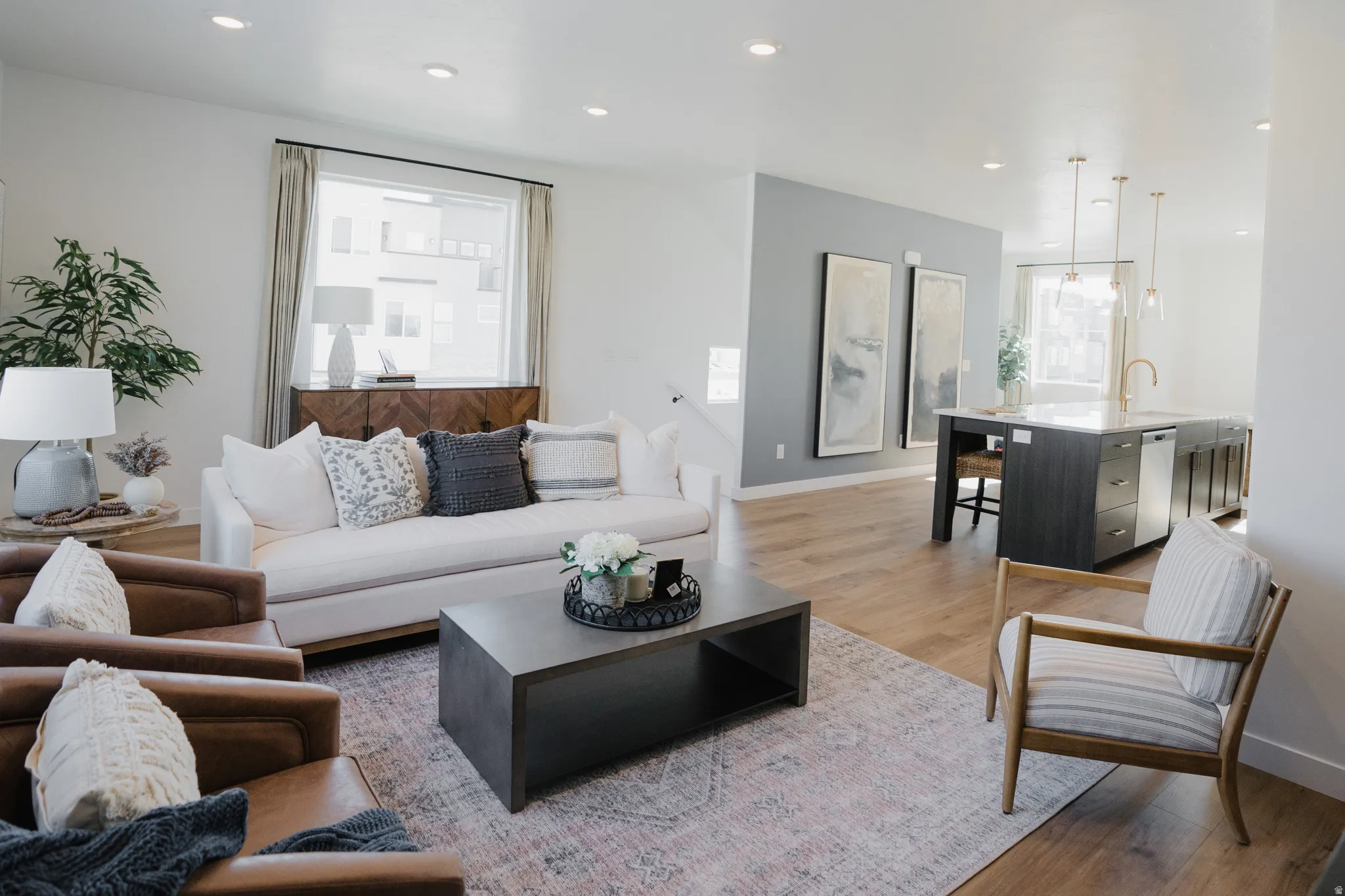 Open-concept living area featuring wood-finish flooring, recessed lighting, and a neutral color palette