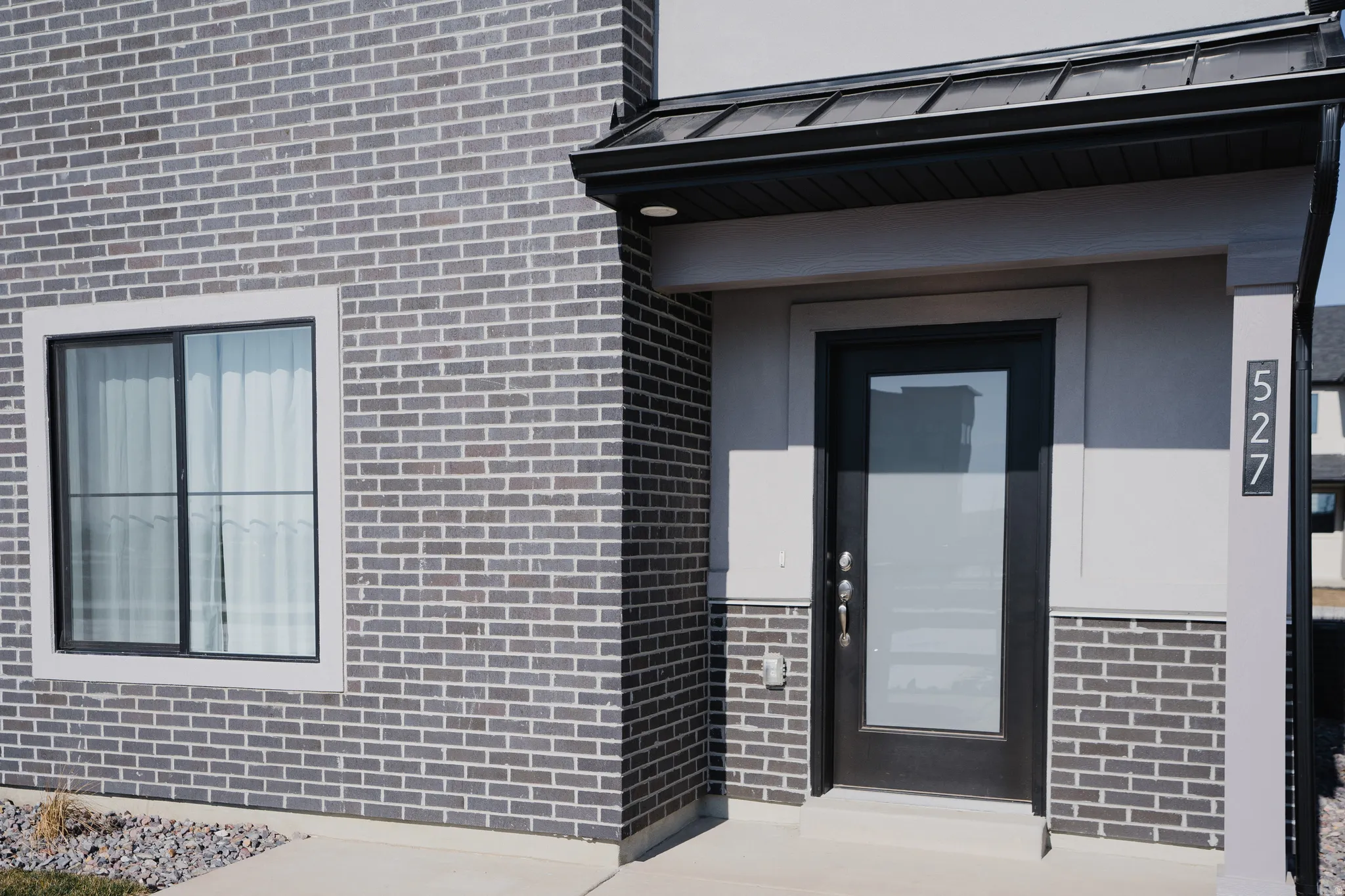 Modern facade featuring grey brick and stucco finishes
