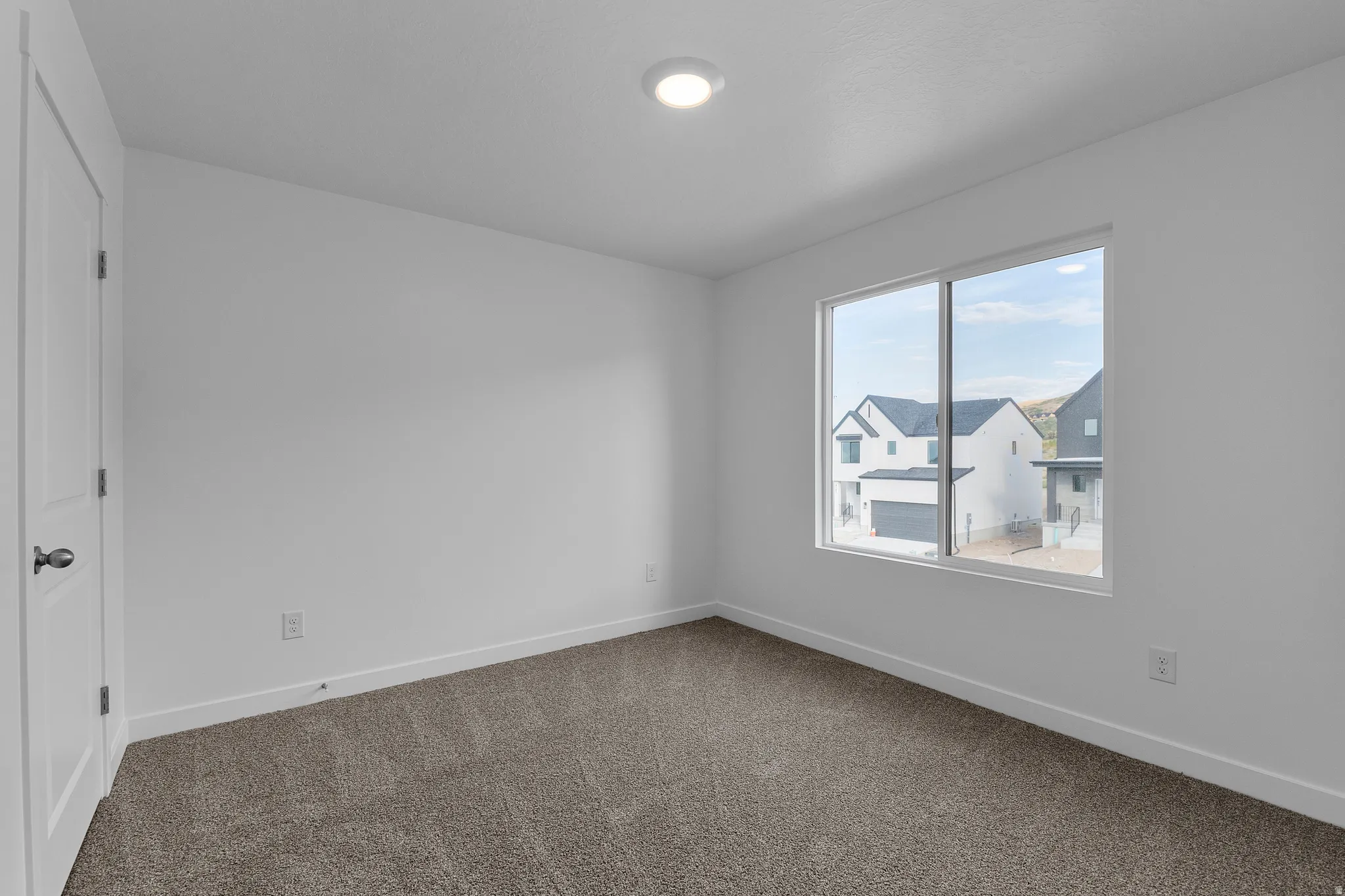 Bright interior space featuring a window with a neighborhood backdrop