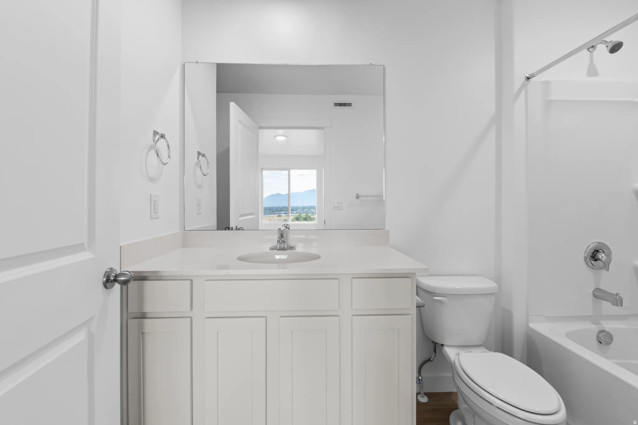 Bathroom featuring a white vanity with panel cabinetry and a light-colored countertop