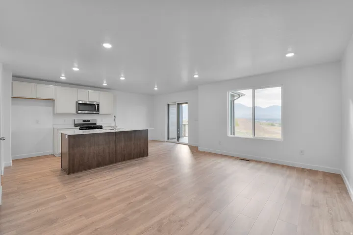 Open-concept living space featuring wood-finish flooring, recessed lighting, and white walls