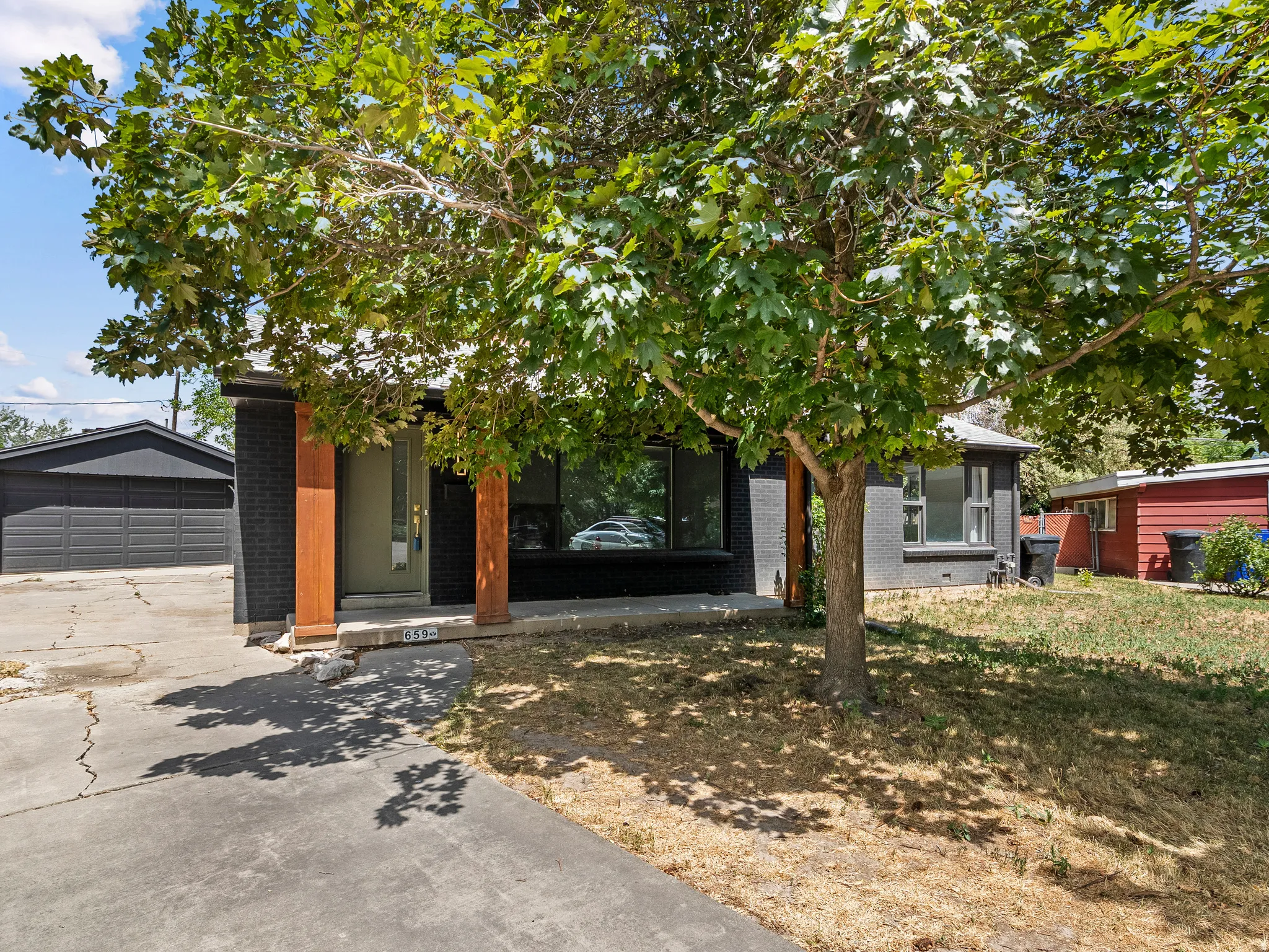 Exterior featuring dark brick siding and wood columns flanking the entrance