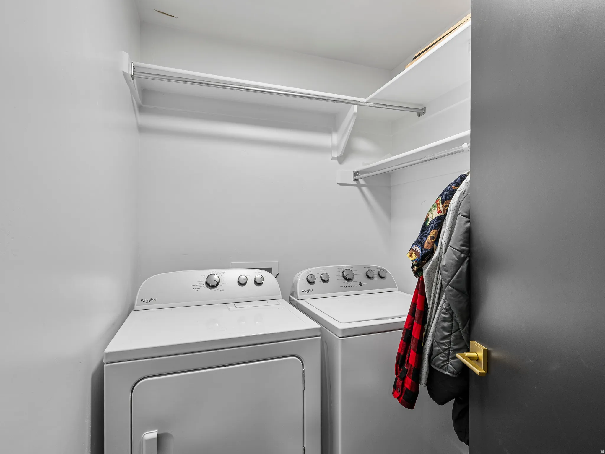 Laundry area featuring built-in shelving and a clothing rod