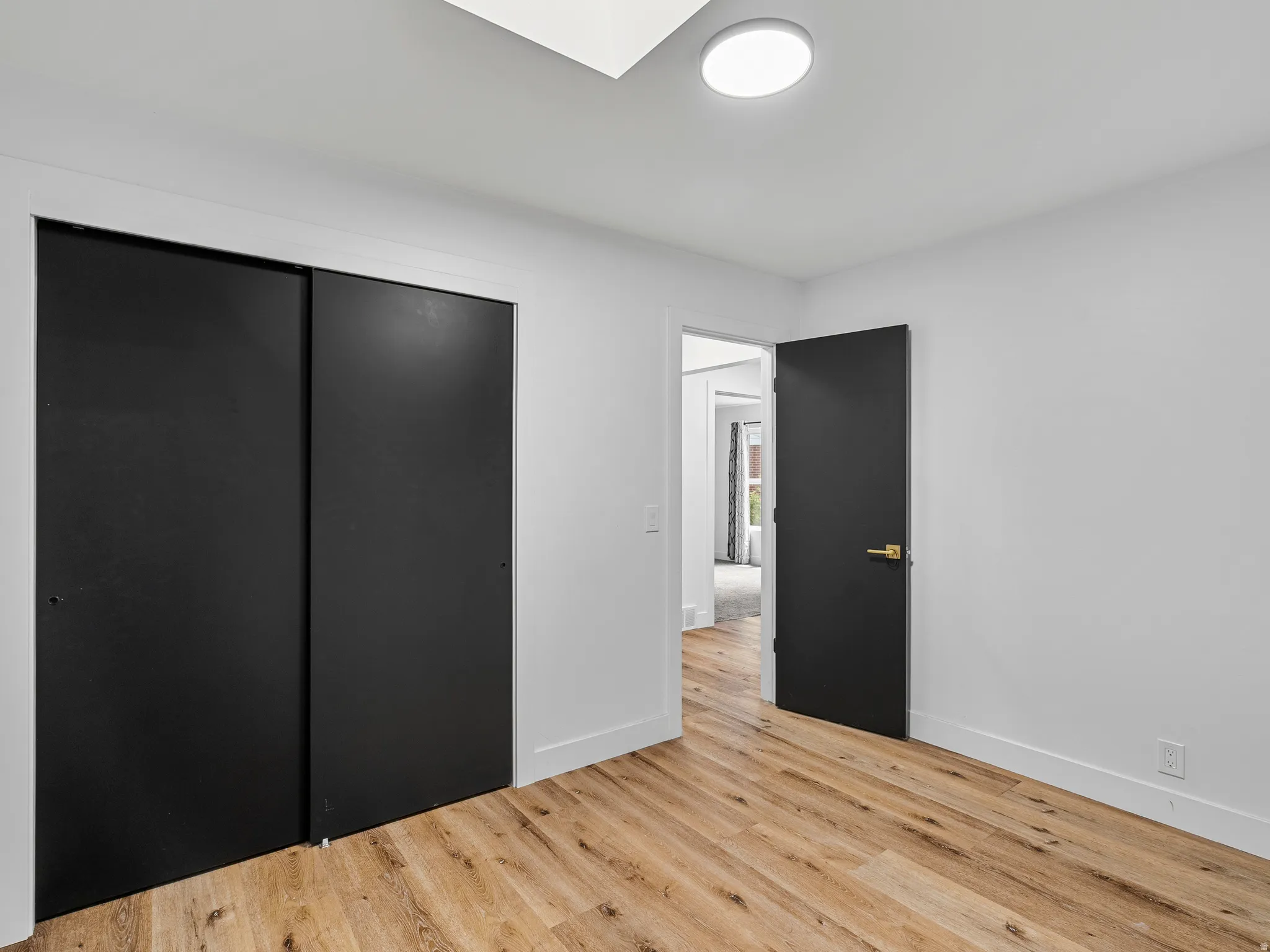 Room featuring wood-finish flooring, white walls, and a recessed ceiling light