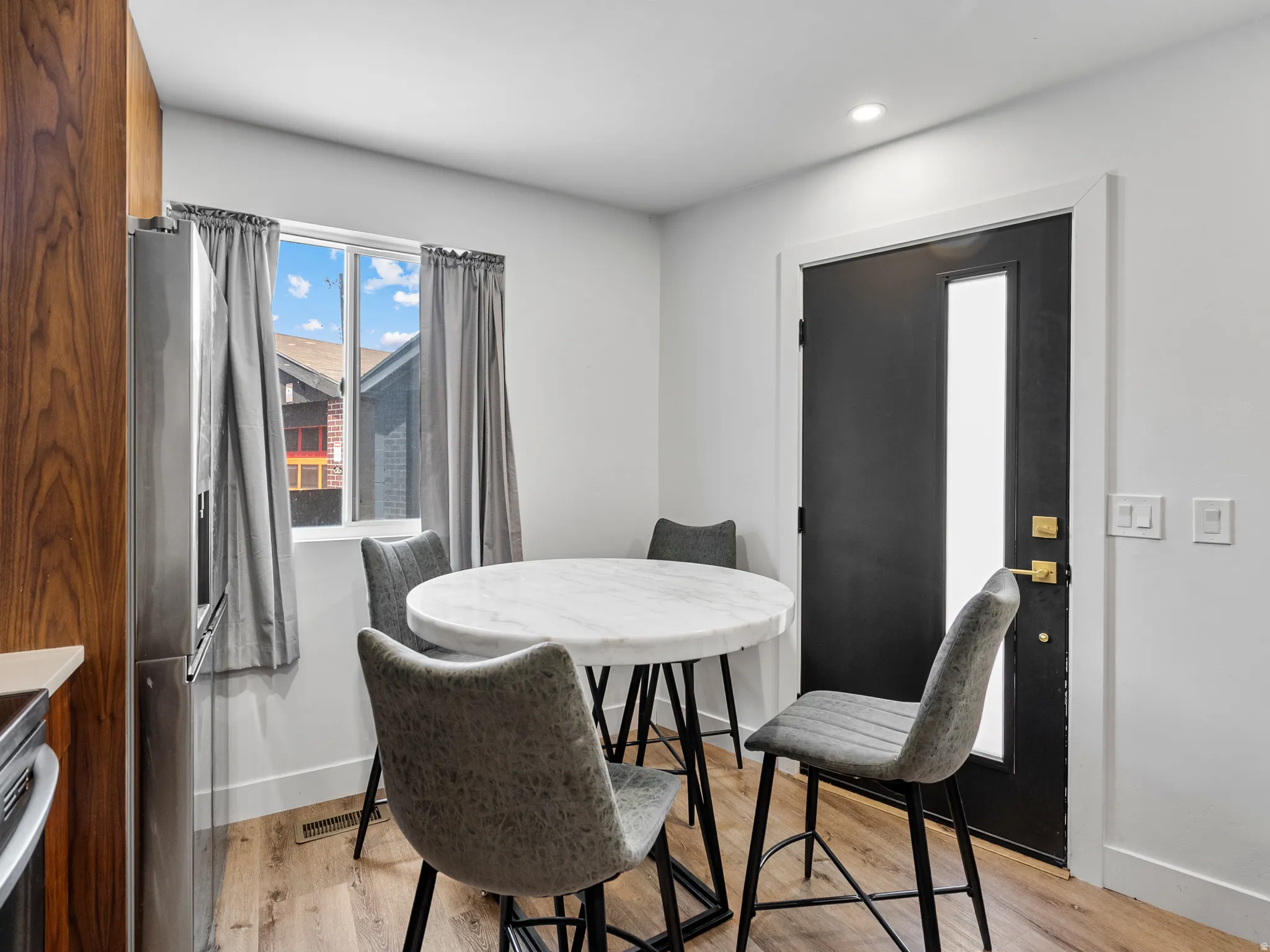 Dining area with wood-finish flooring and a window with natural light