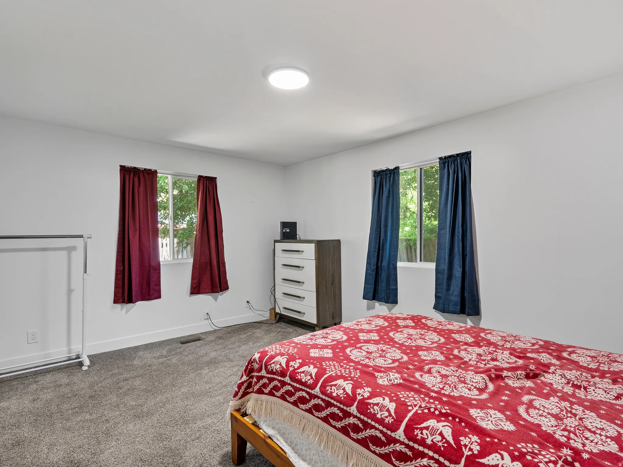 Bright interior space featuring two windows, neutral wall tones, and gray carpeting