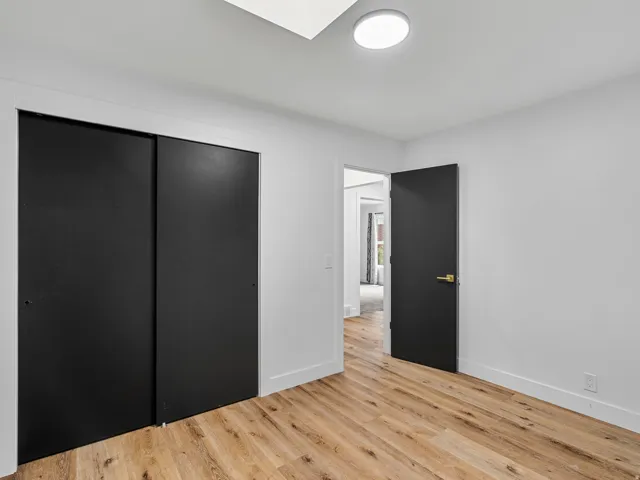 Room featuring wood-finish flooring, white walls, and a recessed ceiling light