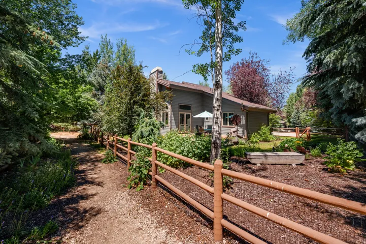 Expansive natural landscaping with a meandering path and rustic split-rail fencing