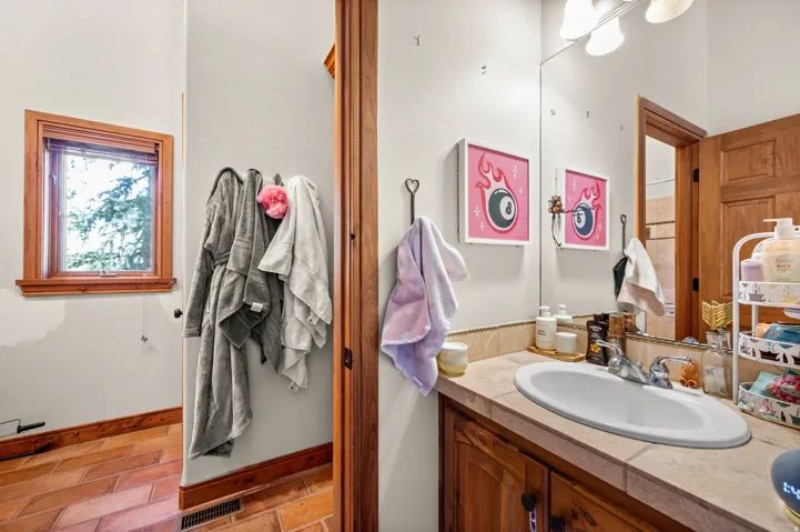 Bathroom vanity with a built-in oval sink, dual-handle chrome faucet, and a large mirror