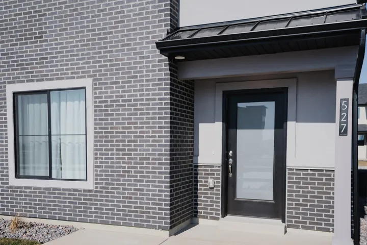 Modern facade featuring grey brick and stucco finishes