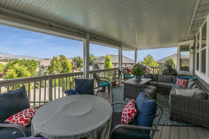 Expansive covered deck featuring a textured ceiling, durable composite flooring, and white railing