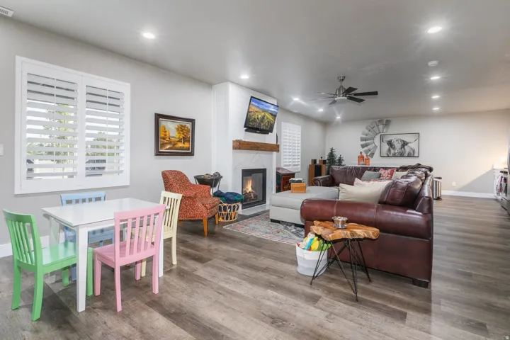 Spacious living area featuring wood-finish flooring, recessed lighting, and a ceiling fan