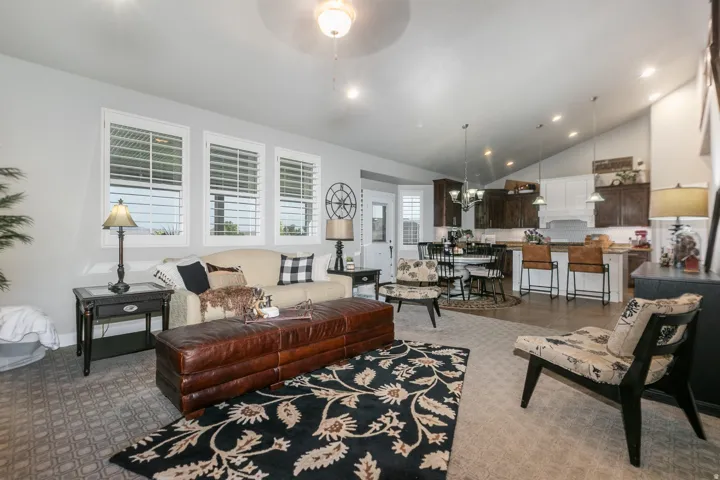 Open concept living space featuring vaulted ceilings, recessed lighting, and a kitchen with an island and pendant lighting