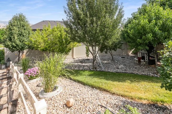 Expansive backyard featuring a combination of manicured lawn and decorative gravel landscaping