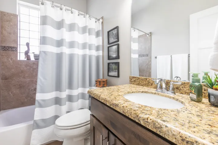 Bathroom featuring a vanity with a light-toned stone countertop and an undermount sink