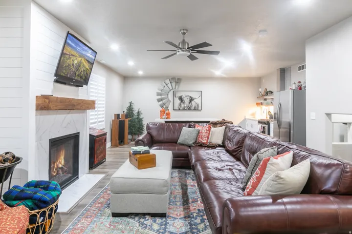 Living area featuring a fireplace with a white tile surround and a wood mantel