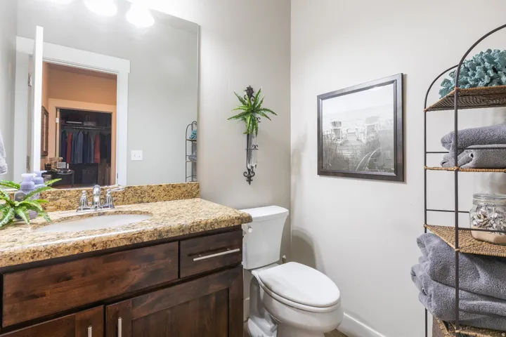 Bathroom featuring a dark wood-finish vanity with a granite countertop and an integrated sink