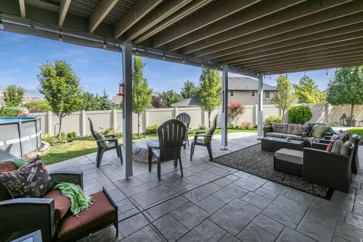 Expansive covered patio featuring stamped concrete flooring and string lighting