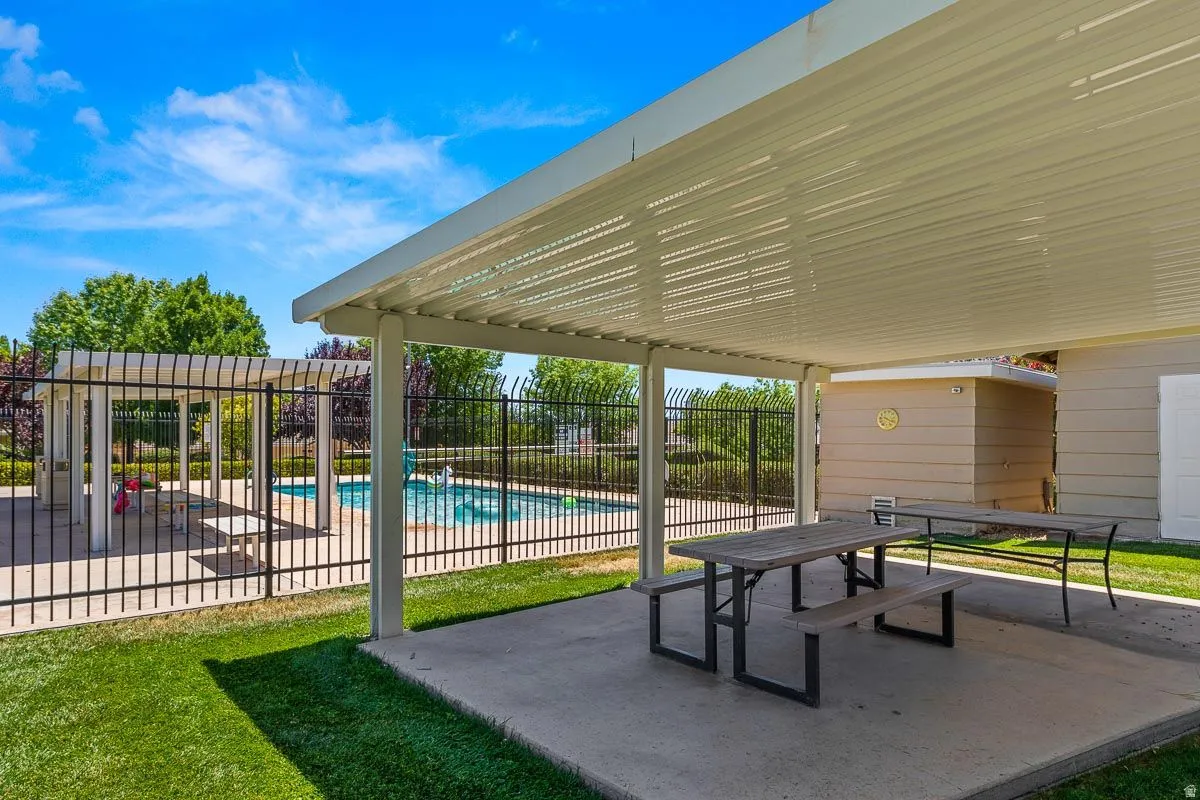 Covered patio area with concrete flooring, providing ample outdoor entertaining space