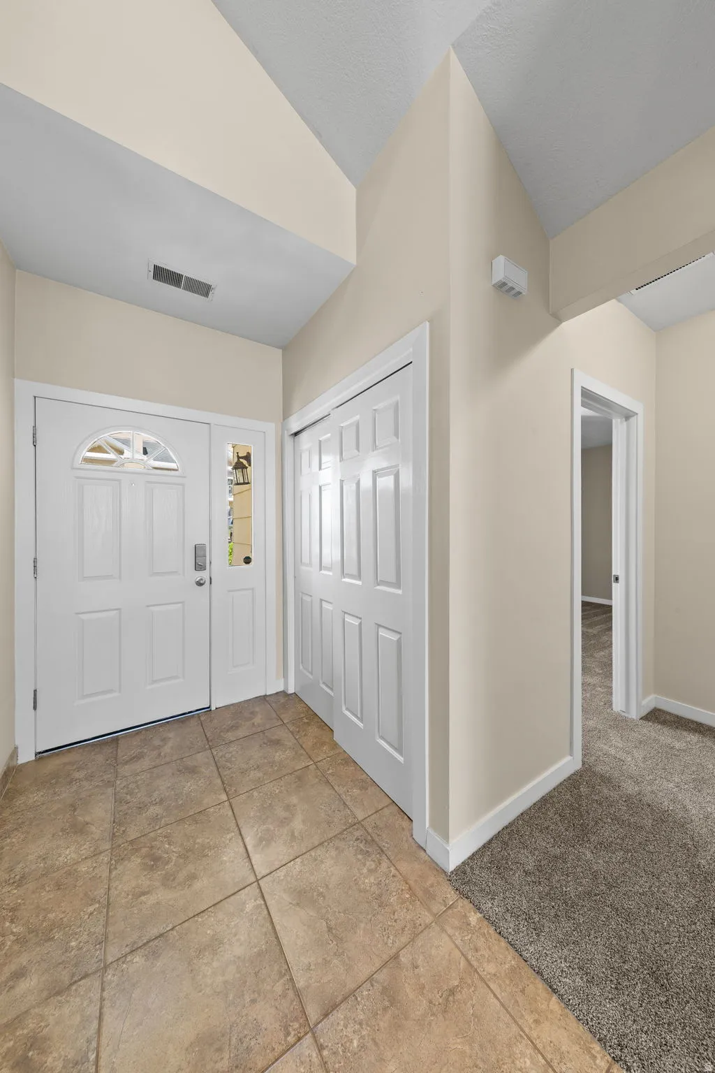 Foyer entry featuring ceramic tile flooring, a double front door with decorative glass inserts, and a bifold door closet