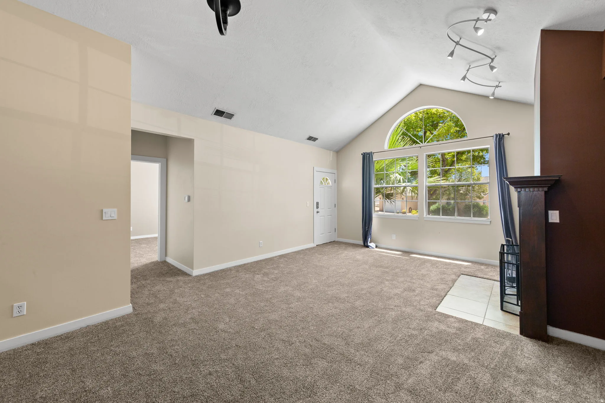 Vaulted ceilings highlight a window with an arched transom