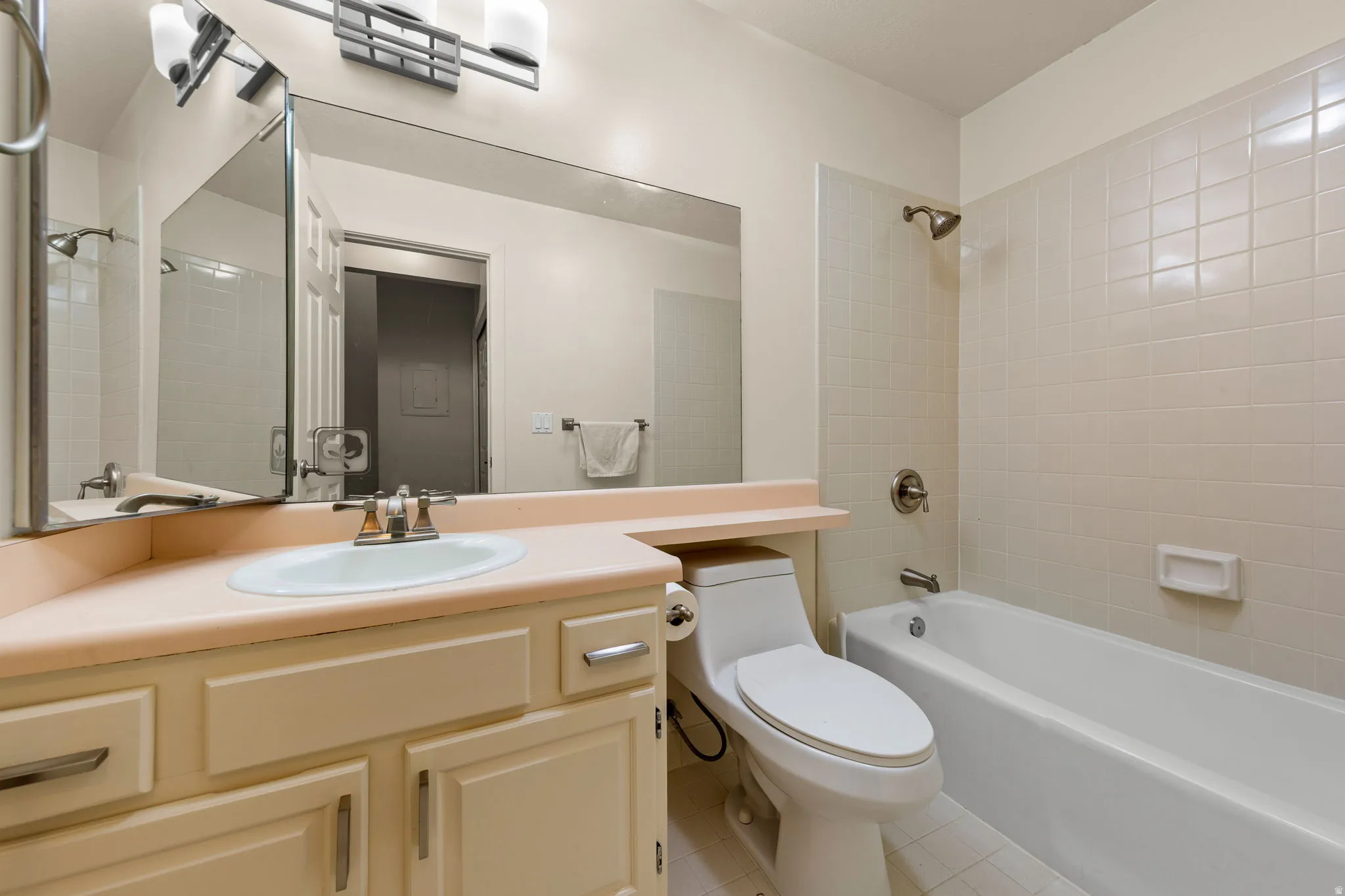 Bathroom featuring a vanity with an integrated sink, a full-width mirror, and overhead sconce lighting
