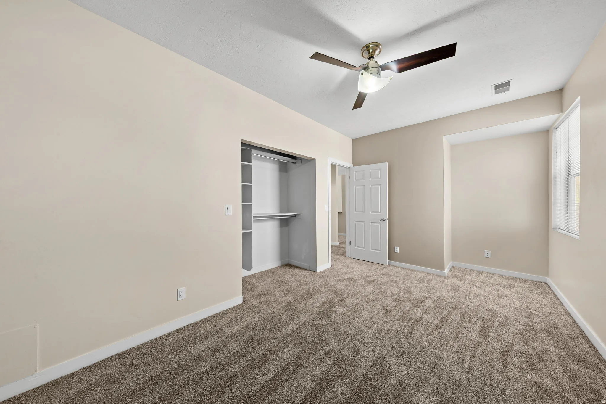 Carpeted room with neutral wall tones and white trim