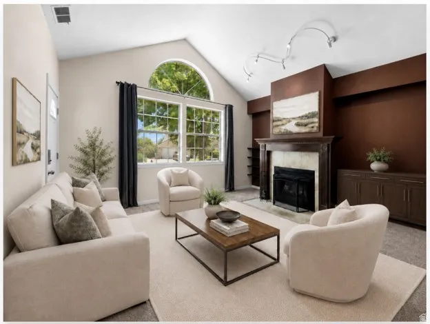 Vaulted ceiling living area featuring a fireplace with a wood mantle, an arched window, and a built-in credenza