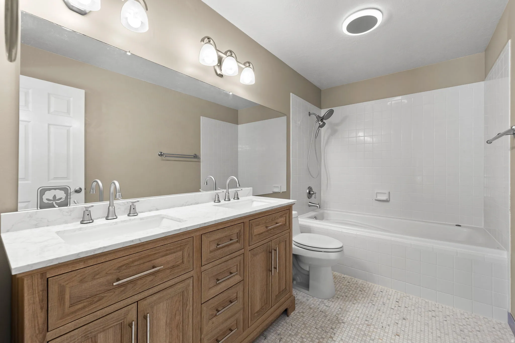 Bathroom featuring a double vanity with stone countertop, dual undermount sinks, and brushed nickel fixtures