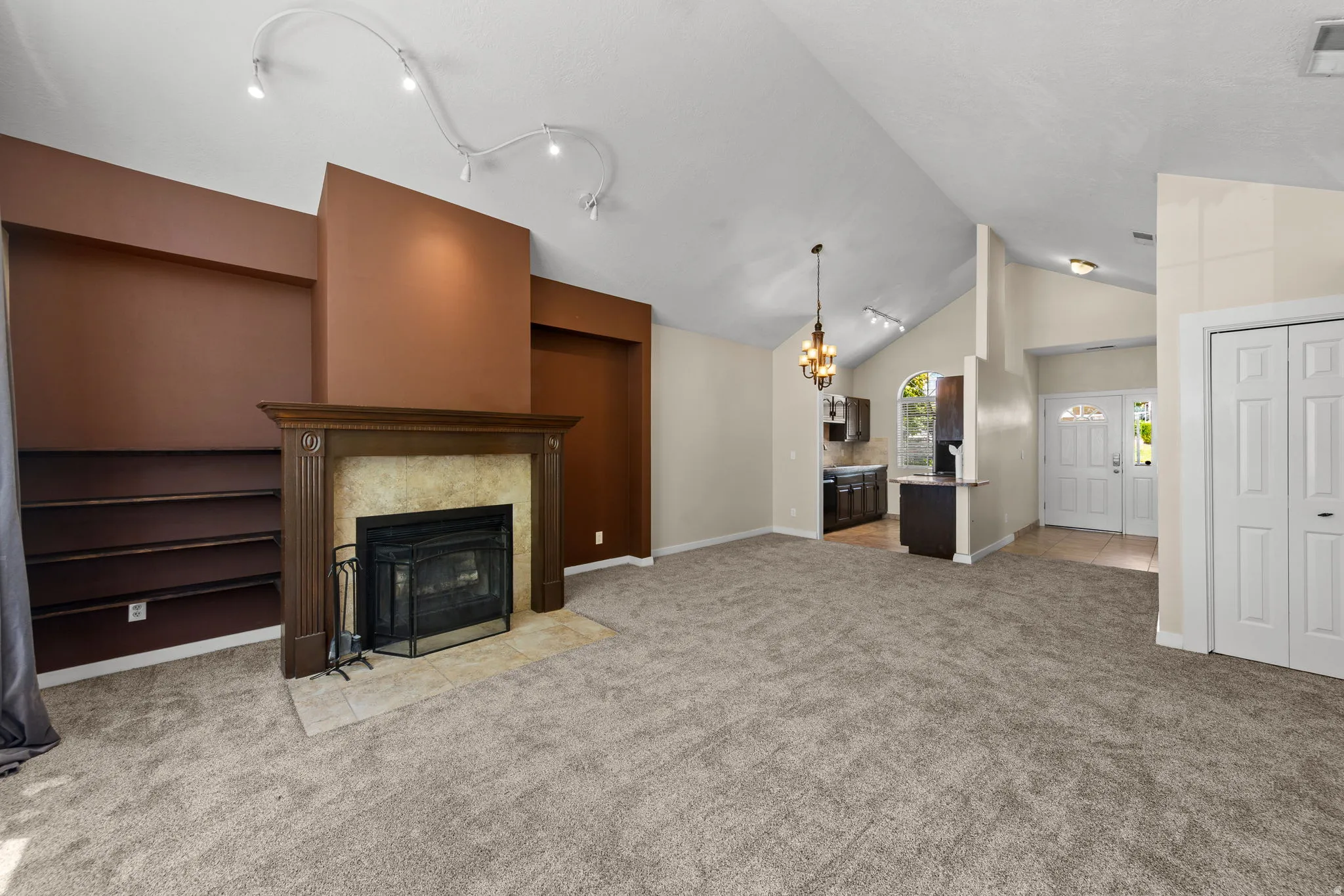 Spacious interior featuring a vaulted ceiling and an ornate fireplace with a stone surround