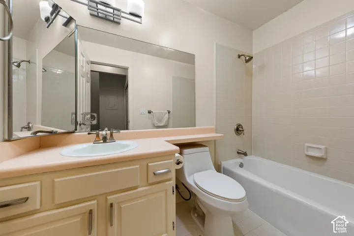 Bathroom featuring a vanity with an integrated sink, a full-width mirror, and overhead sconce lighting
