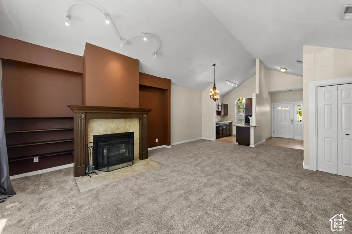 Spacious interior featuring a vaulted ceiling and an ornate fireplace with a stone surround