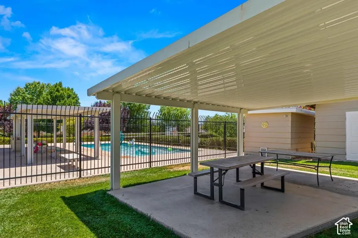 Covered patio area with concrete flooring, providing ample outdoor entertaining space
