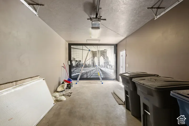 Spacious garage interior featuring concrete flooring, painted walls, and a prominent graphic wall covering