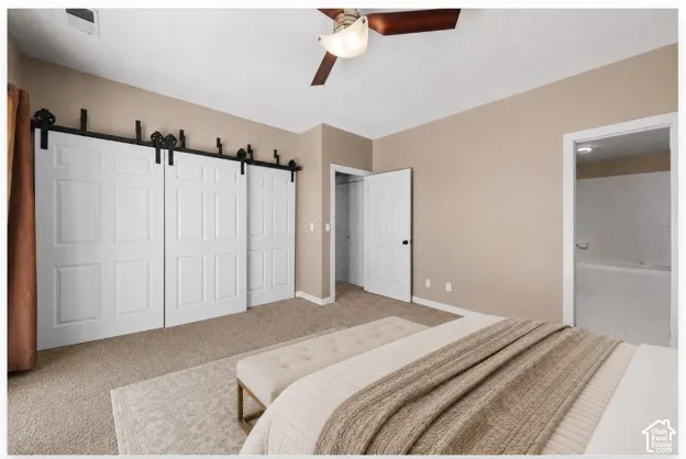 Bedroom featuring neutral-toned walls, plush carpeting, and a ceiling fan with integrated lighting