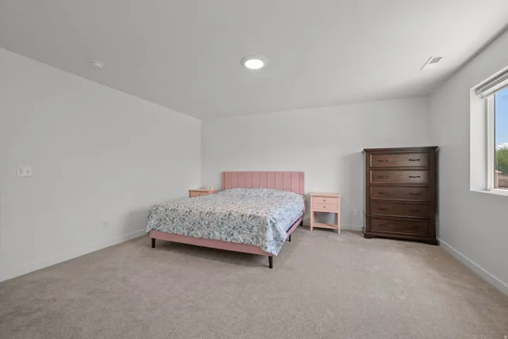 Spacious room with light gray carpeting, neutral wall color, and a recessed ceiling light