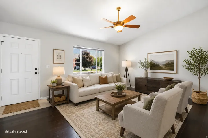 Dark wood-finish flooring with light-toned walls, a large window, and a ceiling fan with integrated lighting