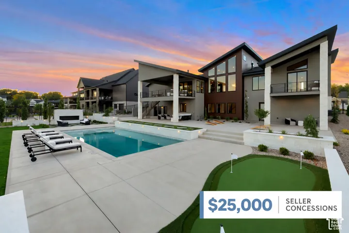 Expansive concrete patio featuring an in-ground pool, built-in putting green, and multiple balconies