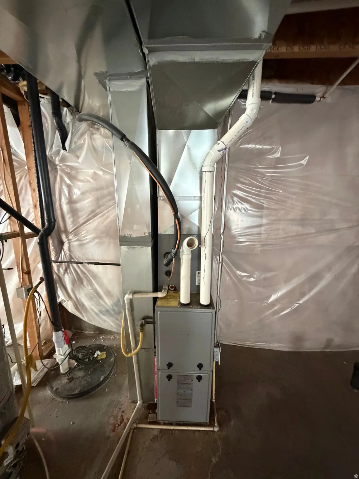 HVAC system featuring a furnace unit and associated ductwork, piping, and wiring