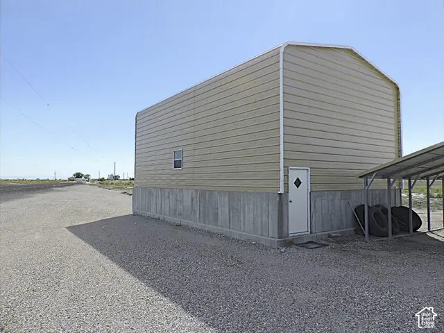 Metal shop featuring a concrete foundation, a single window, and a white entrance door
