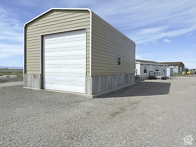 Metal building with a roll-up door, concrete foundation, and horizontal siding