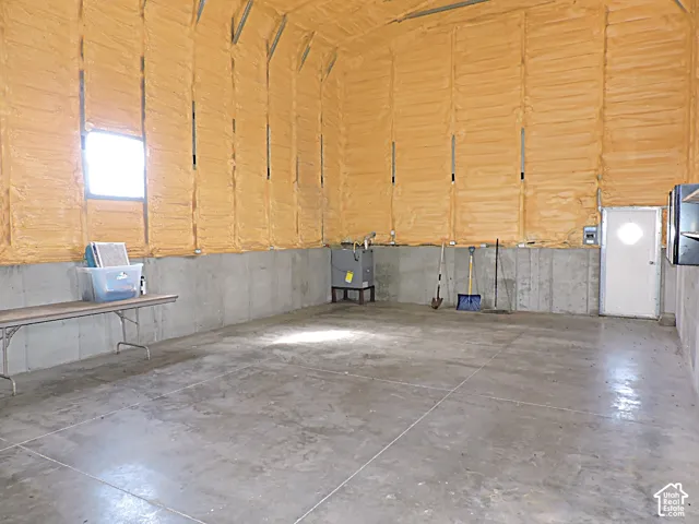 Spacious utility area featuring concrete flooring, and insulated upper walls