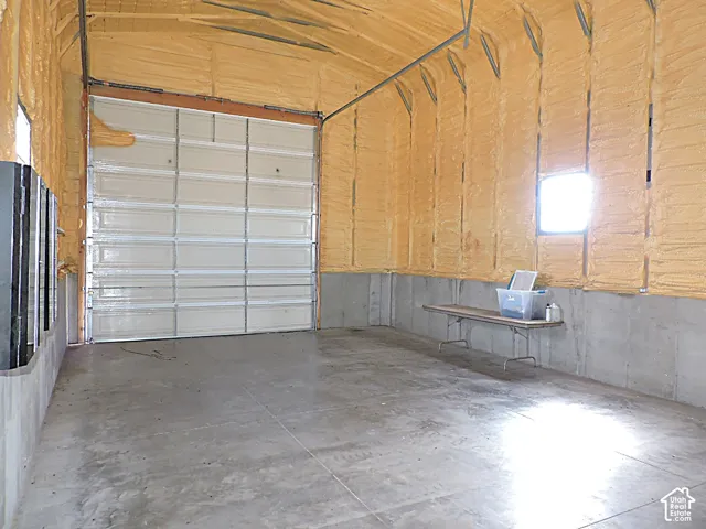 Concrete flooring with a single roll-up door and insulated walls
