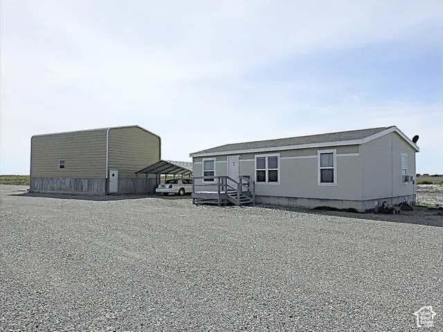 Gravel parking area with a manufactured home and a separate metal building