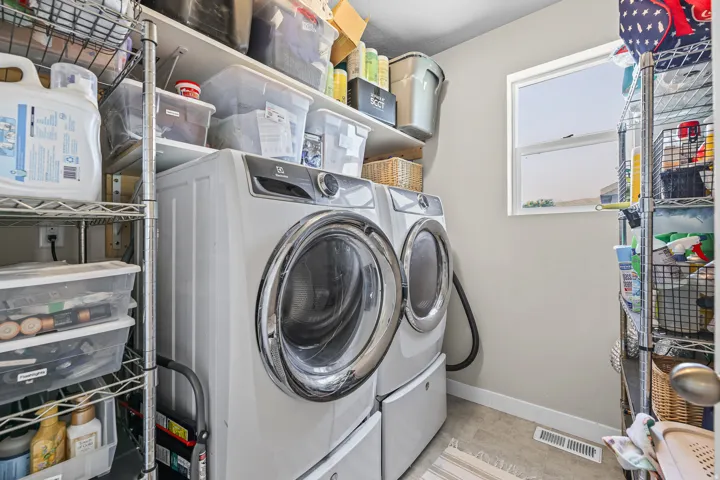 Dedicated laundry area featuring a front-loading washer and dryer set