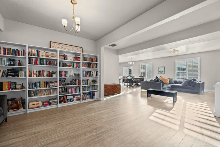 Spacious open-concept interior featuring light wood-finish flooring, built-in shelving, and recessed lighting