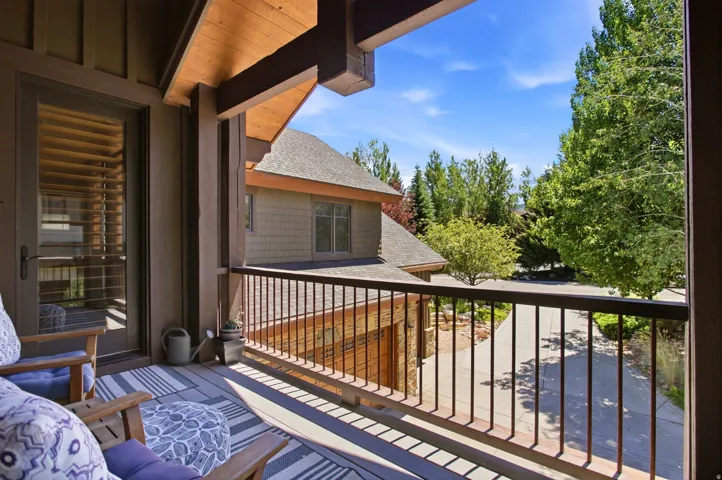 Covered balcony featuring wood-finish ceiling, vertical siding, a door with internal blinds, and a metal railing